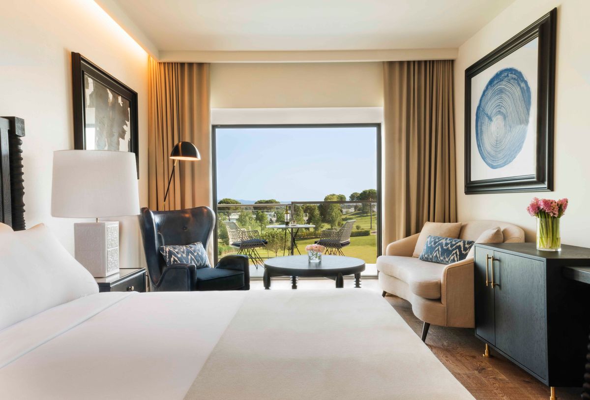 Superior Deluxe room with a large bed, armchair and terrace view