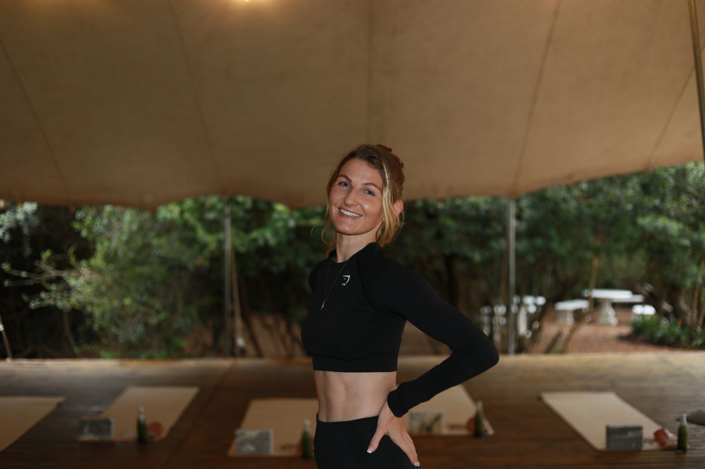 Simone Estelle smiling, hand on hip, in black training wear