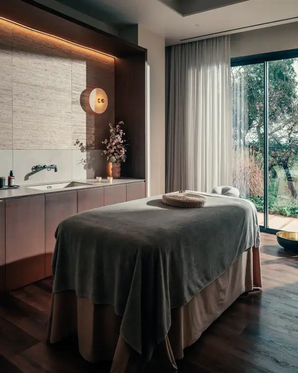 Calm treatment room with a massage table by the window